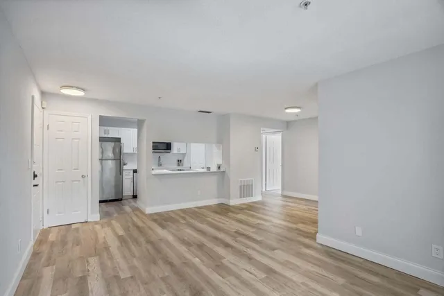 a view of a kitchen with wooden floor and a sink