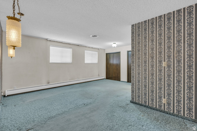 10705 Green Ridge Drive Sandy, UT 84070 - Photo 14 of 55 Unfurnished room featuring a baseboard heating unit, carpet flooring, and a textured ceiling