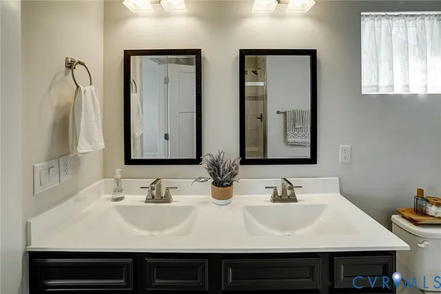 a bathroom with double vanity sinks and a mirror