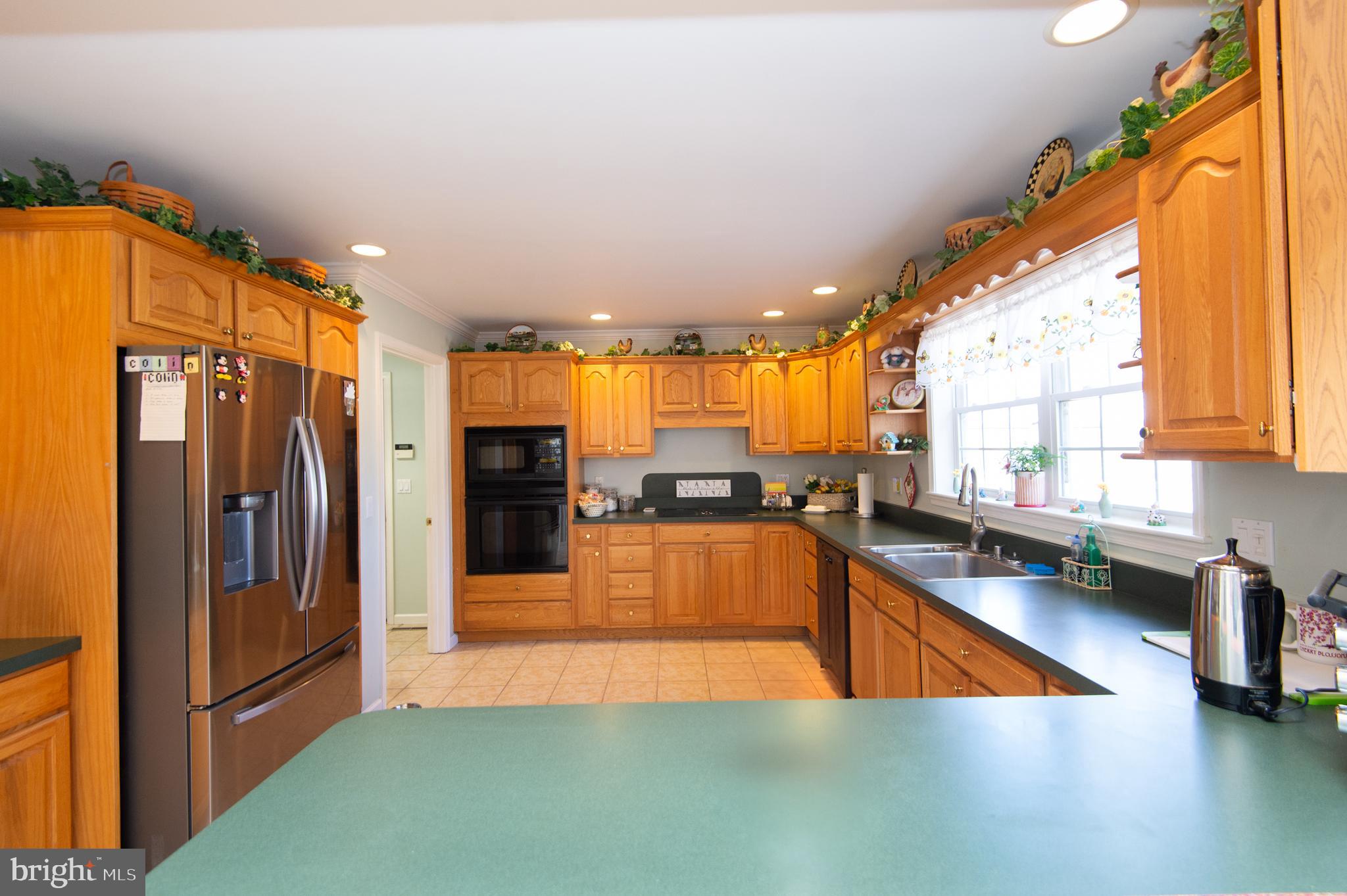 9 Holly Terrace Cambridge, MD 21613 - Photo 14 of 49 a view of a kitchen with kitchen island a large window cabinets and stainless steel appliances