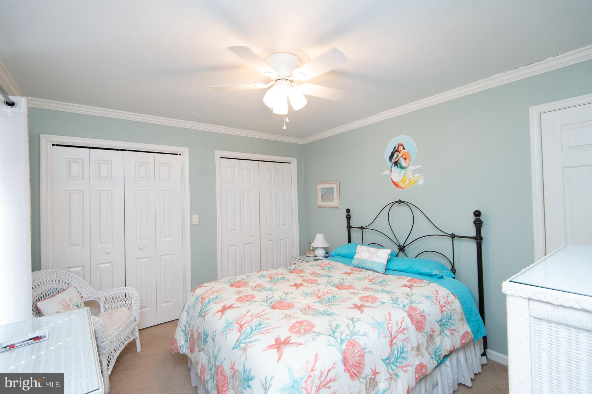 9 Holly Terrace Cambridge, MD 21613 - Photo 36 of 49 a bedroom with a bed and a chandelier