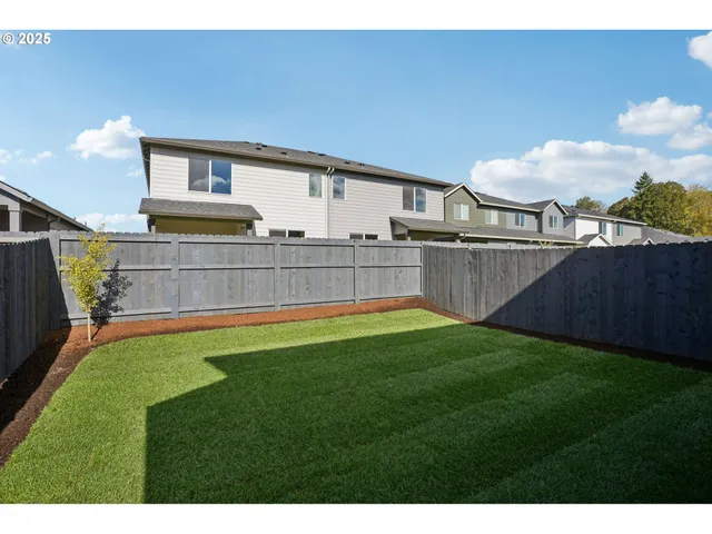 a view of a backyard with plants and outdoor seating