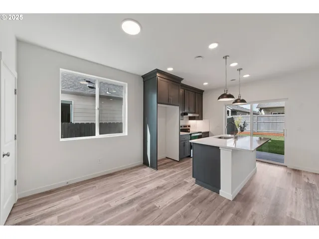 a kitchen with stainless steel appliances kitchen island wooden floors and white cabinets