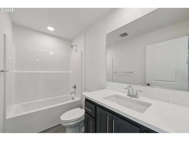 a bathroom with a sink a toilet a mirror and shower