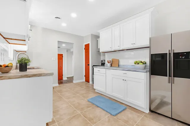 a kitchen with granite countertop white cabinets and white appliances
