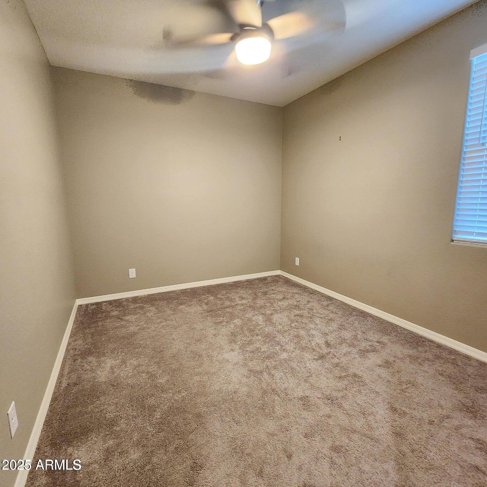 7925 South 24th Way Phoenix, AZ 85042 - Photo 15 of 19 an empty room with a ceiling fan and window