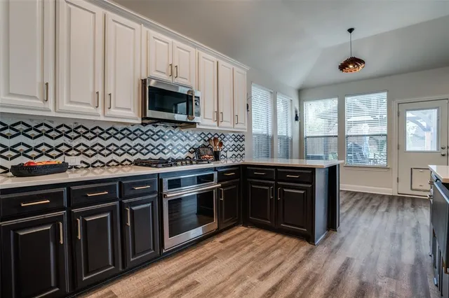 a kitchen with stainless steel appliances granite countertop a stove a sink and a microwave