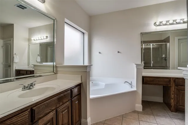 a bathroom with a tub sink and mirror