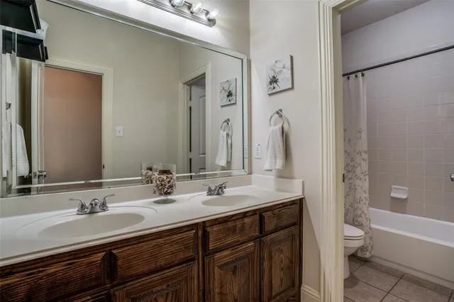 a bathroom with a granite countertop sink double vanity and a bathtub