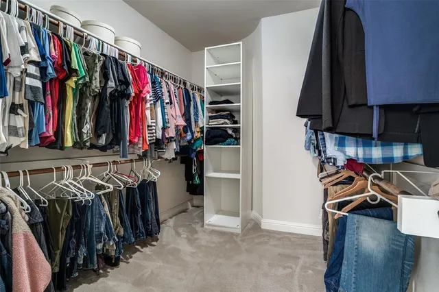 a view of walk in closet with clothes