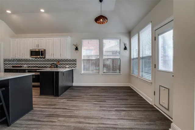 a kitchen with stainless steel appliances granite countertop a stove a sink dishwasher and a microwave oven with cabinets