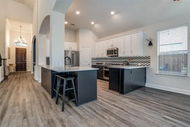 a kitchen with stainless steel appliances a stove a sink dishwasher and a oven with wooden cabinets