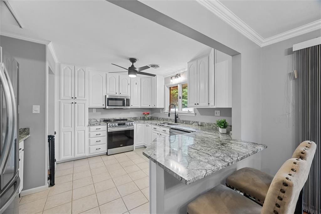 124 Heath Drive Baden, PA 15005 - Photo 15 of 42 a kitchen with stainless steel appliances granite countertop a stove refrigerator sink and cabinets