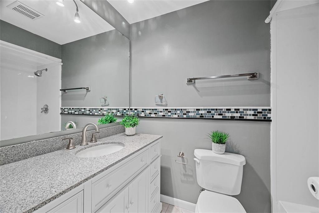 124 Heath Drive Baden, PA 15005 - Photo 26 of 42 a bathroom with a granite countertop toilet sink and mirror