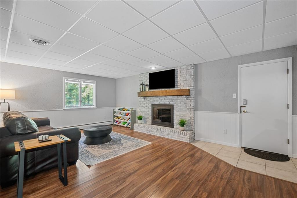 124 Heath Drive Baden, PA 15005 - Photo 32 of 42 a living room with furniture a fireplace and a flat screen tv