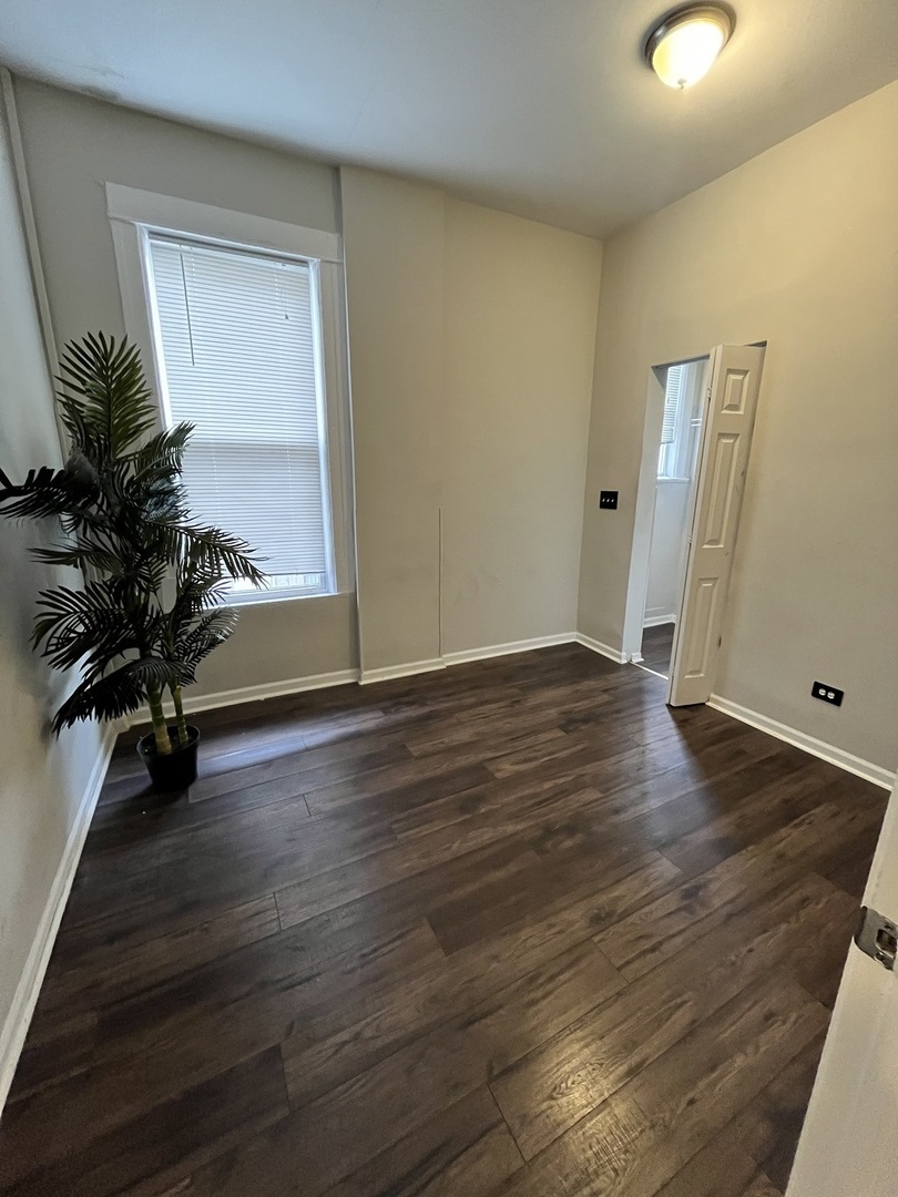 847 East 65th Street, Unit 2 Chicago, IL 60637 - Photo 11 of 13 an empty room with wooden floor and windows