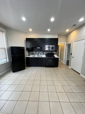 a large kitchen with a refrigerator and a stove top oven