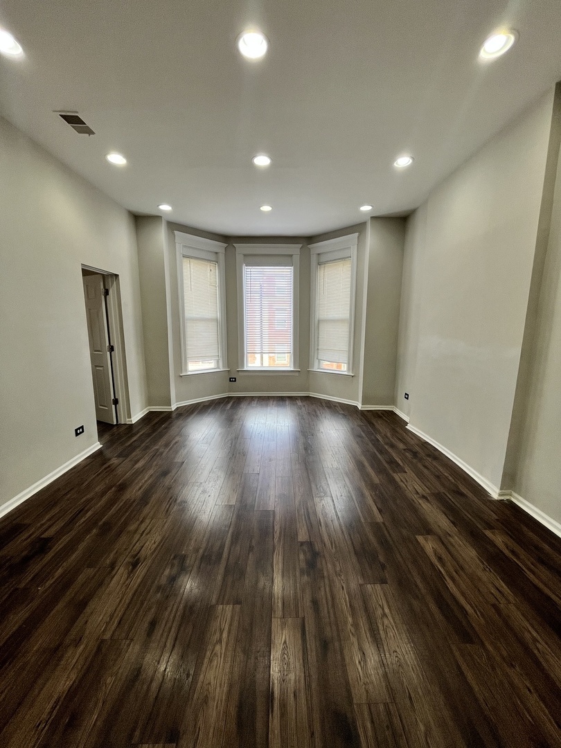 847 East 65th Street, Unit 2 Chicago, IL 60637 - Photo 7 of 13 a view of an empty room with wooden floor and a window