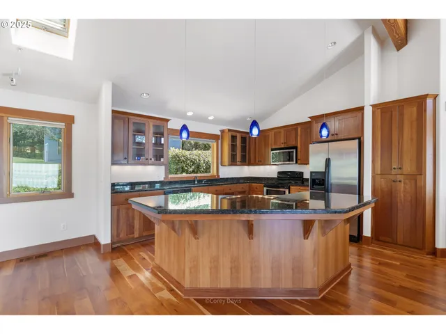 a kitchen with stainless steel appliances granite countertop sink stove and refrigerator