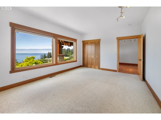 a view of an empty room with window and cabinet
