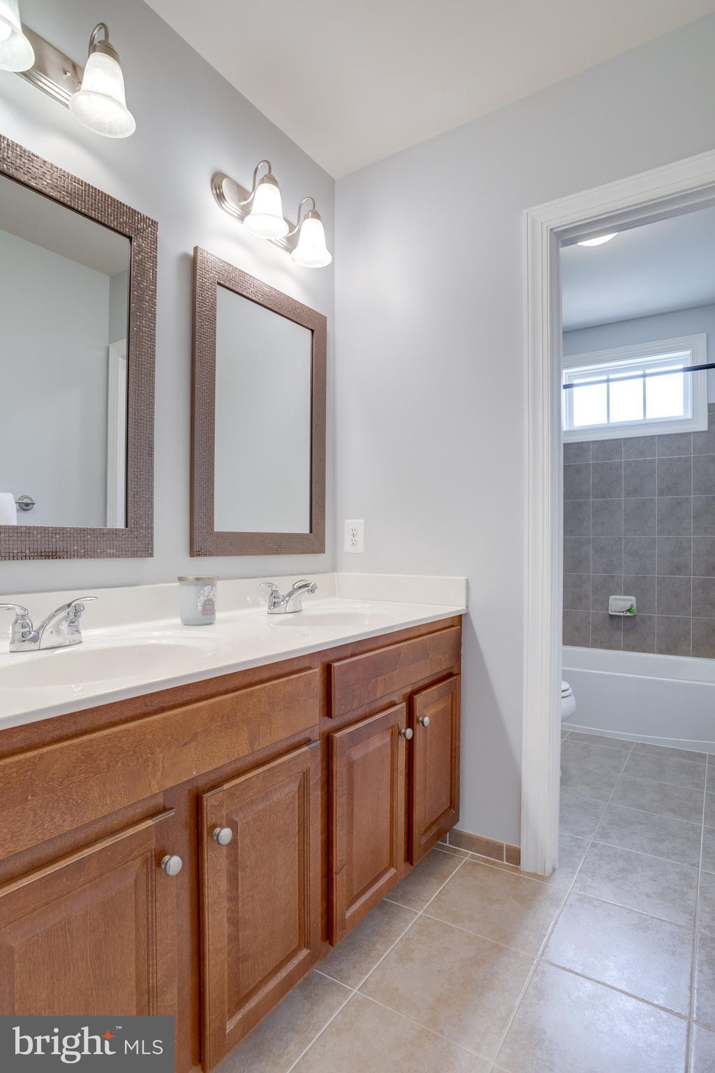 18475 Kerill Road Triangle, VA 22172 - Photo 71 of 99 a bathroom with a double vanity sink and mirror