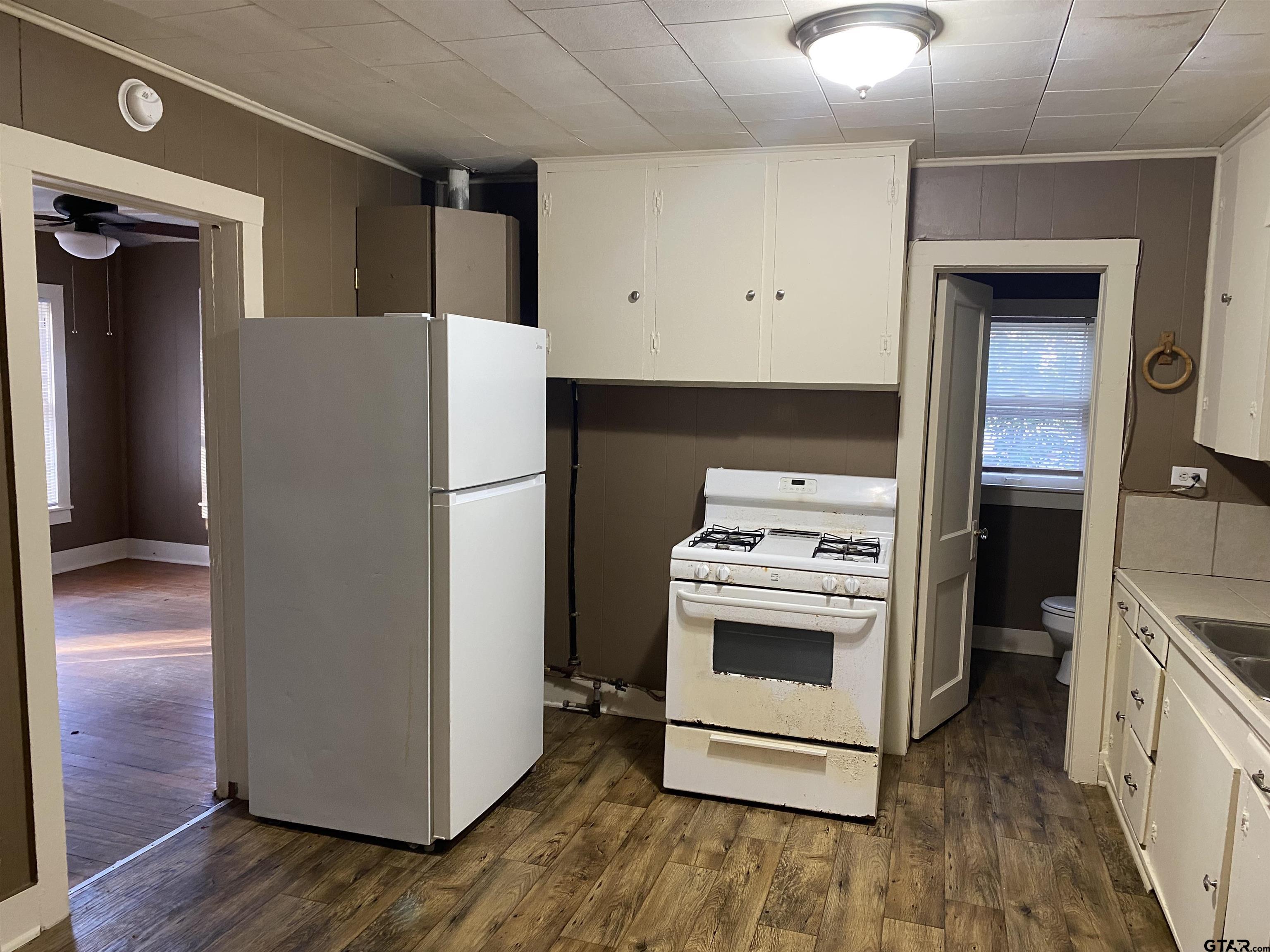 502 3rd Street Quitman, TX 75783 - Photo 11 of 22 a white refrigerator freezer and a stove sitting inside of a kitchen