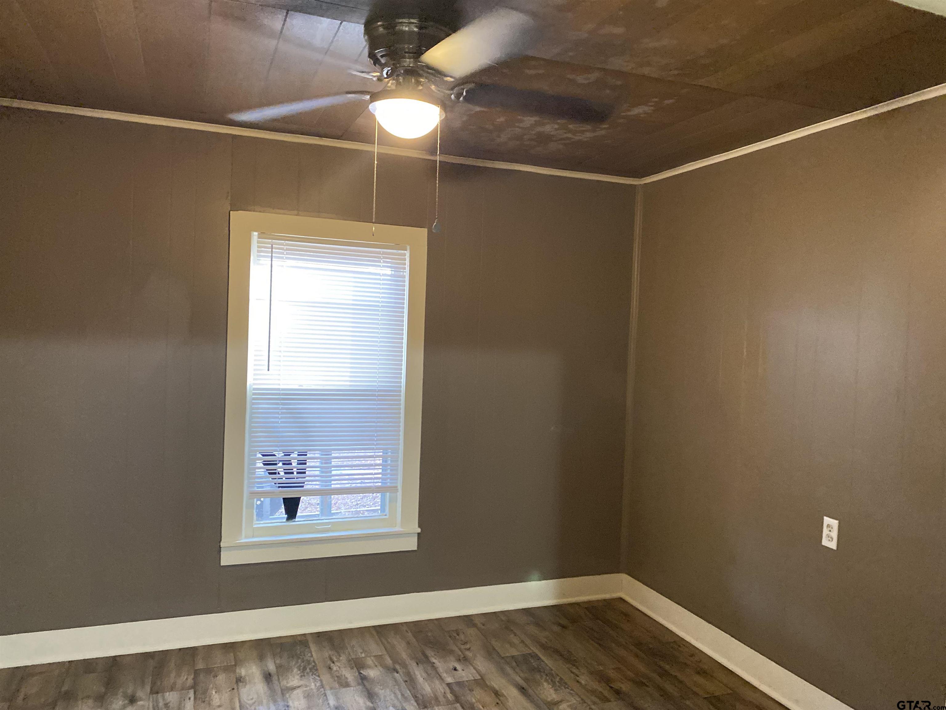 502 3rd Street Quitman, TX 75783 - Photo 18 of 22 a view of an empty room with wooden floor and a window