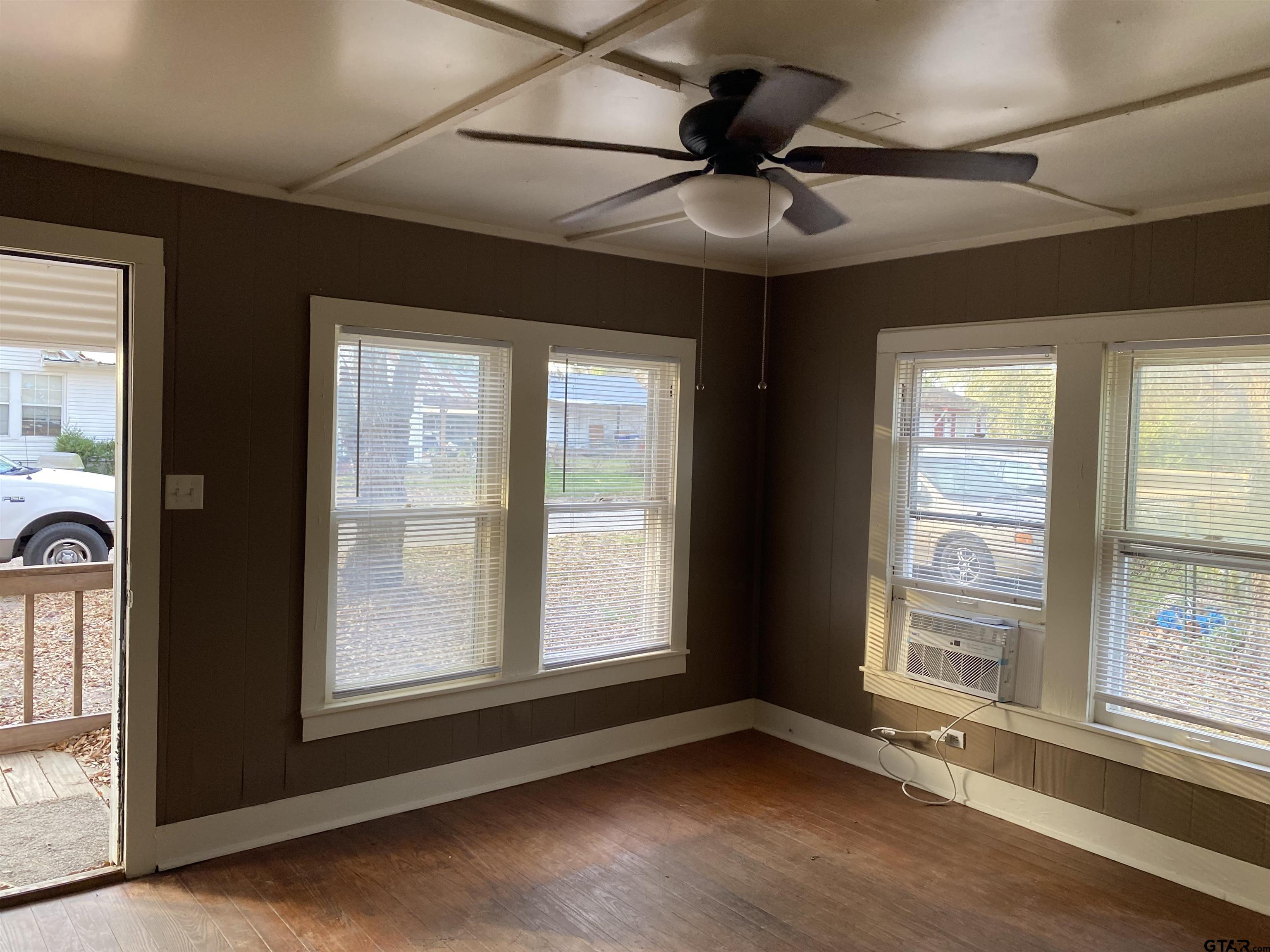 502 3rd Street Quitman, TX 75783 - Photo 5 of 22 a view of an empty room with a window and wooden floor