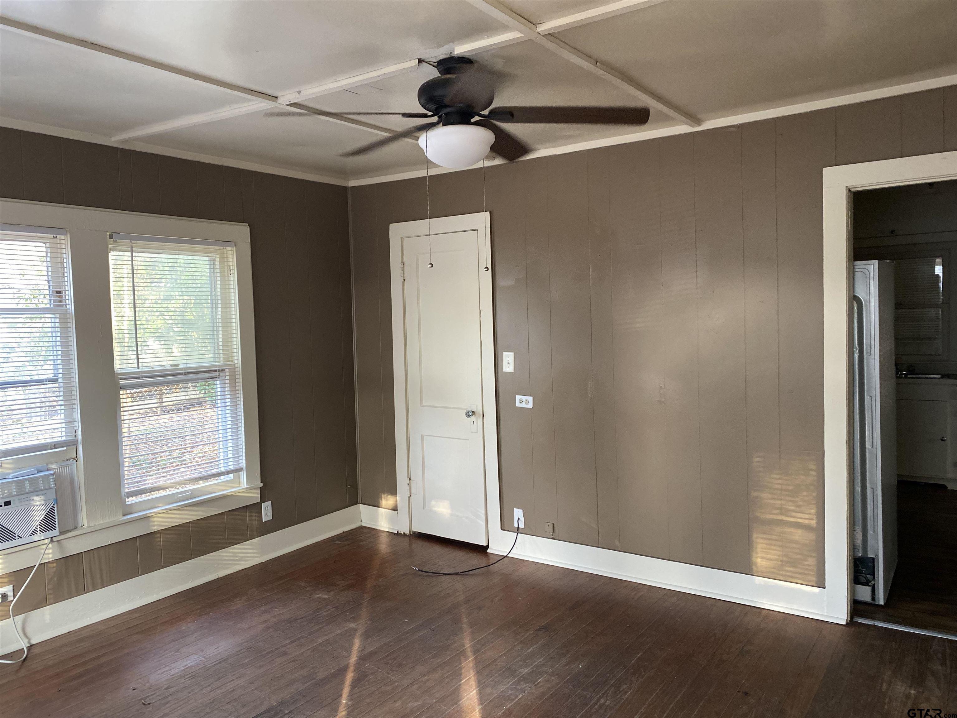 502 3rd Street Quitman, TX 75783 - Photo 7 of 22 an empty room with windows and fan