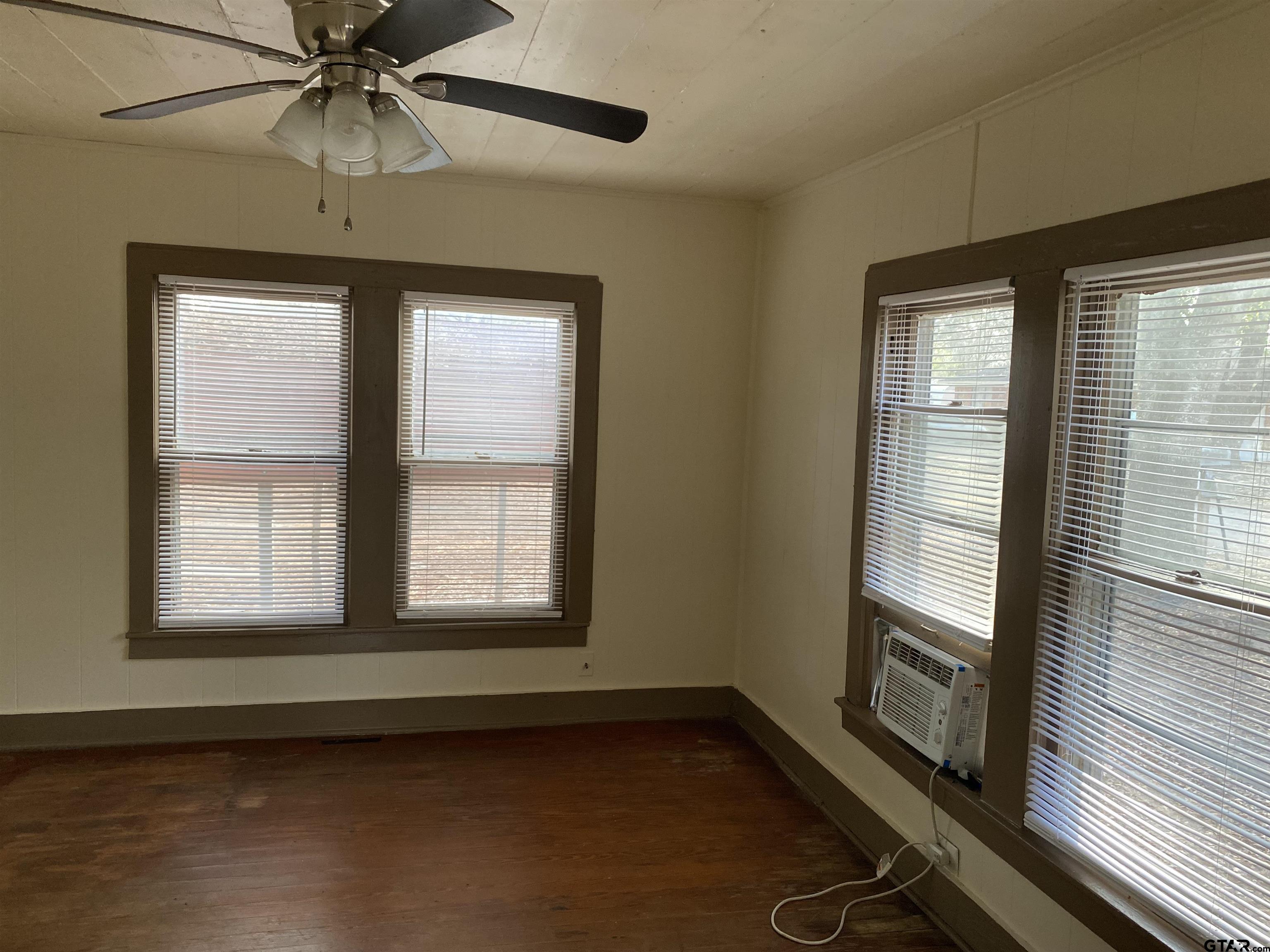 502 3rd Street Quitman, TX 75783 - Photo 9 of 22 a view of an empty room with a window and wooden floor