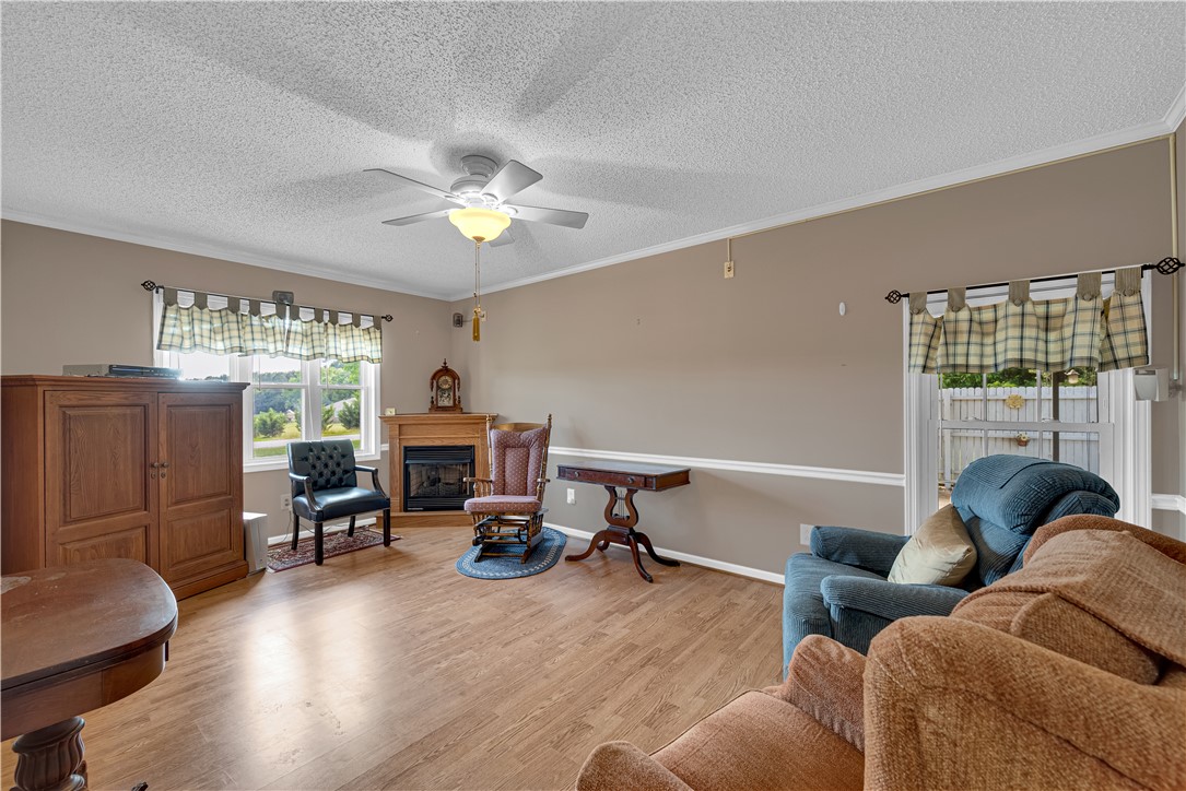 307 Calhoun Road Belton, SC 29627 - Photo 15 of 30 Warm wood-toned flooring extends through this cozy living space with a charming fireplace.