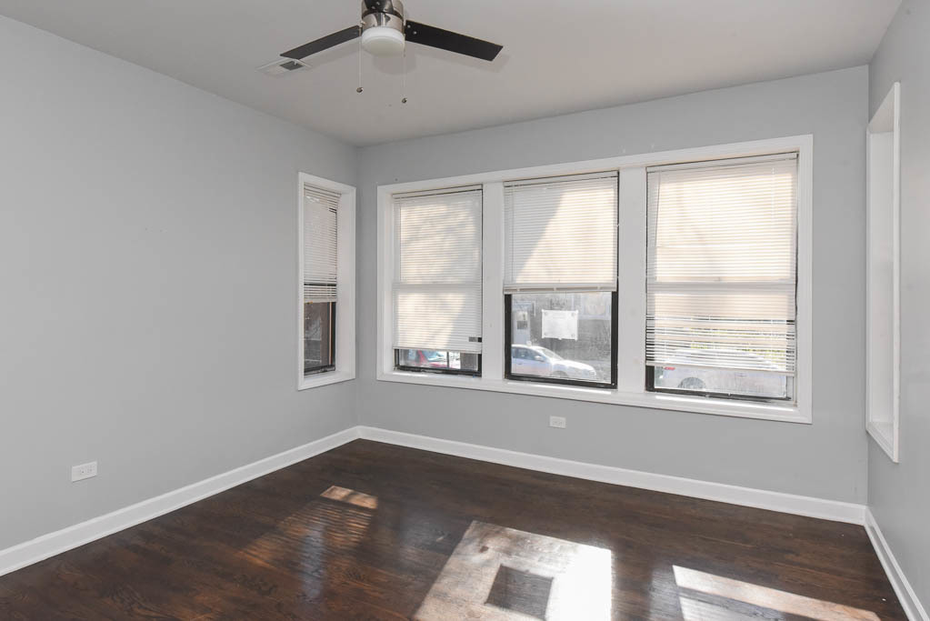 3301 North Harding Avenue, Unit 1E Chicago, IL 60618 - Photo 12 of 21 a view of an empty room with wooden floor and a window