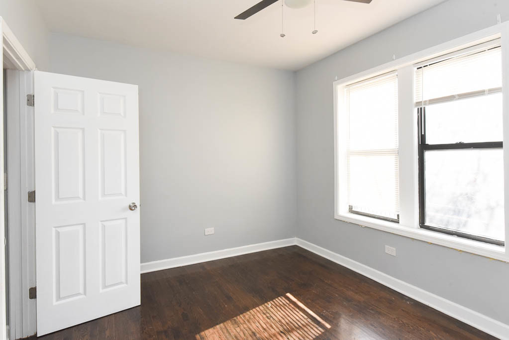 3301 North Harding Avenue, Unit 1E Chicago, IL 60618 - Photo 18 of 21 an empty room with wooden floor and windows