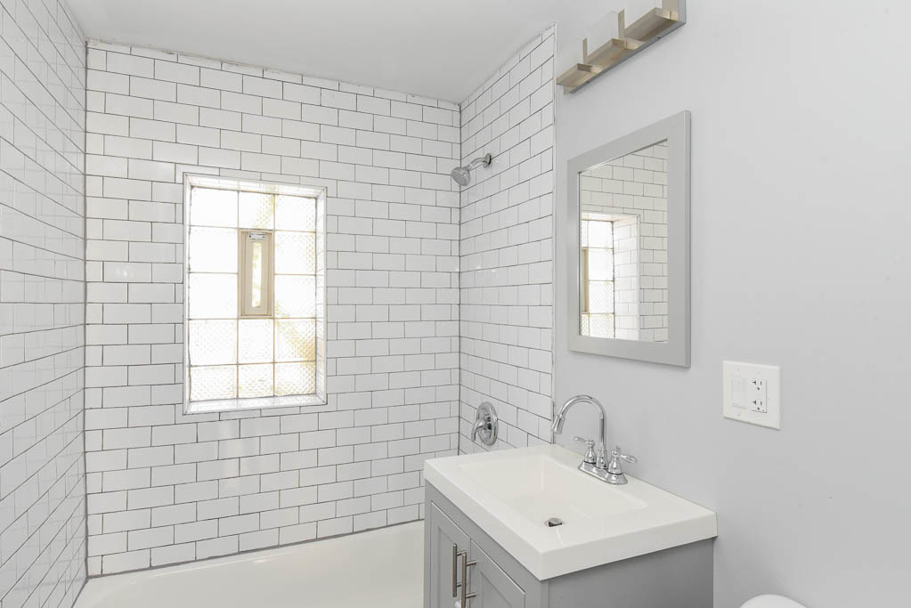 3301 North Harding Avenue, Unit 1E Chicago, IL 60618 - Photo 19 of 21 a bathroom with a sink a mirror and a shower