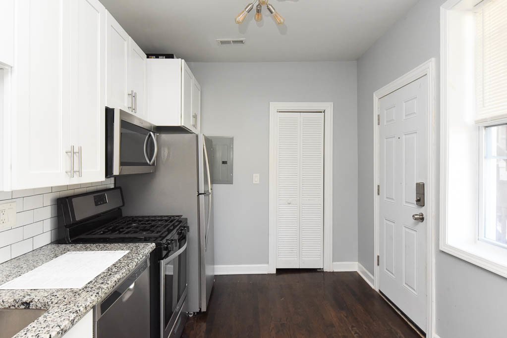 3301 North Harding Avenue, Unit 1E Chicago, IL 60618 - Photo 4 of 21 a kitchen with a refrigerator stove and cabinets