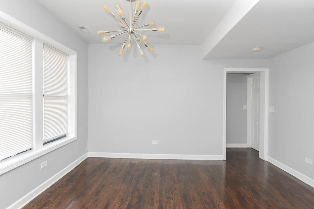 3301 North Harding Avenue, Unit 1E Chicago, IL 60618 - Photo 6 of 21 a view of an empty room with wooden floor and a window