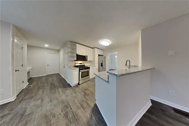 a kitchen with granite countertop a stove top oven and cabinets