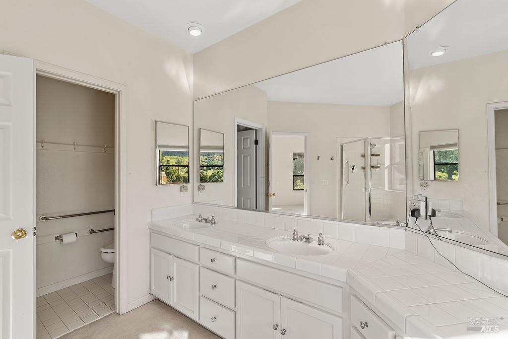 6271 Meadowstone Drive Santa Rosa, CA 95409 - Photo 17 of 24 a bathroom with a double vanity sink mirror double and shower