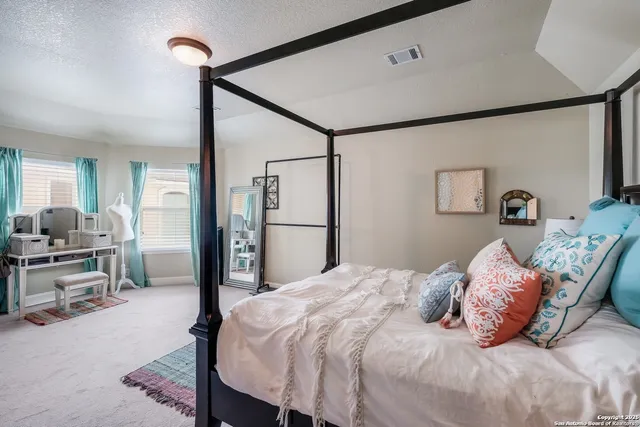 a bedroom with a bed large mirror and a potted plant