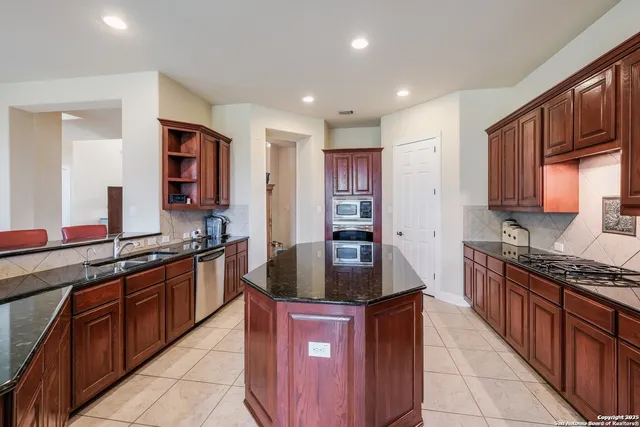 a kitchen with stainless steel appliances granite countertop a stove a sink dishwasher a refrigerator and a oven