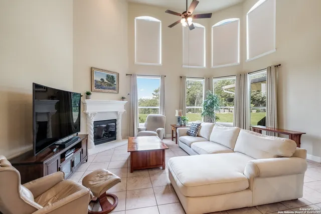 a living room with furniture a flat screen tv and a large window