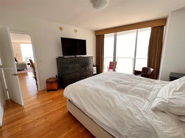a bedroom with a bed and a flat screen tv