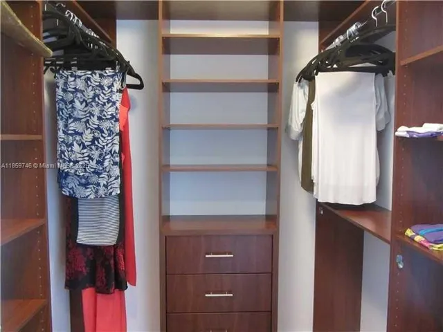 a view of walk in closet with clothes and shoes