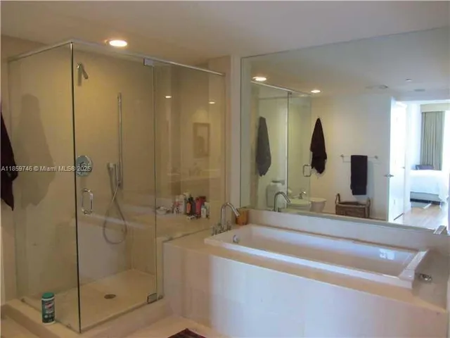 a bathroom with a tub a sink and a shower