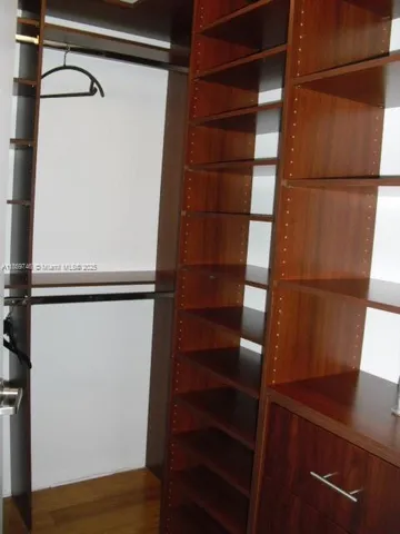 a view of walk in closet with empty racks