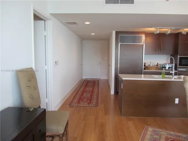a kitchen with kitchen island a counter top space a sink a refrigerator and a stove