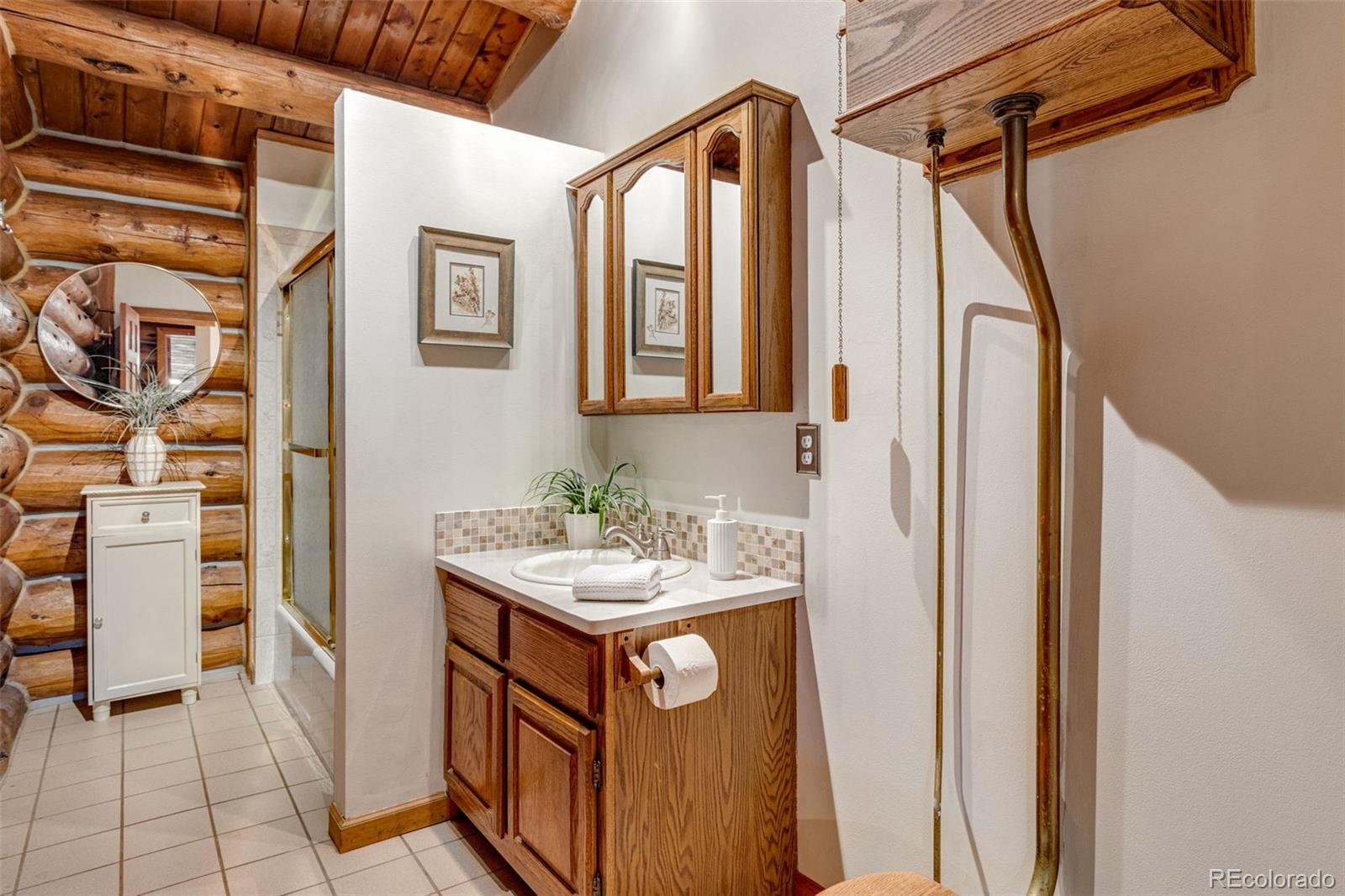7050 Milner Mountain Ranch Road Fort Collins, CO 80526 - Photo 40 of 50 a bathroom with a sink a mirror and a shower
