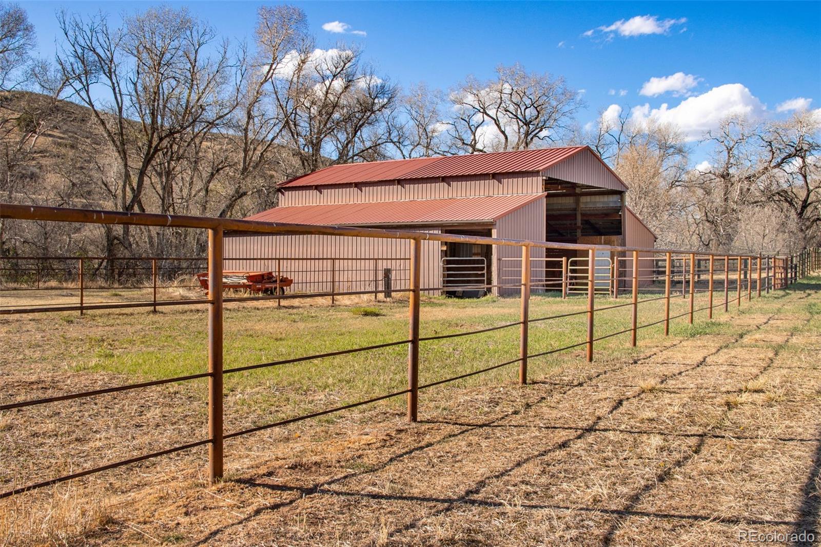 7050 Milner Mountain Ranch Road Fort Collins, CO 80526 - Photo 9 of 50 a view of a white house with a yard
