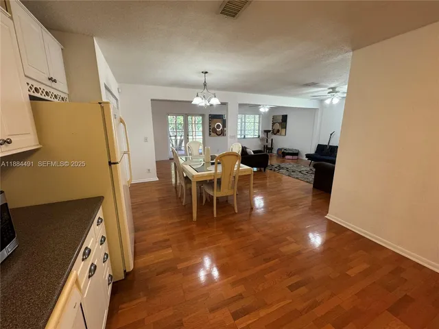 a living room with furniture a chandelier and a dining table