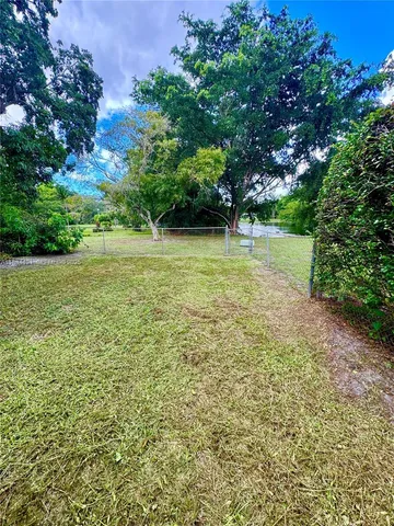 a front view of house with yard and trees in the background